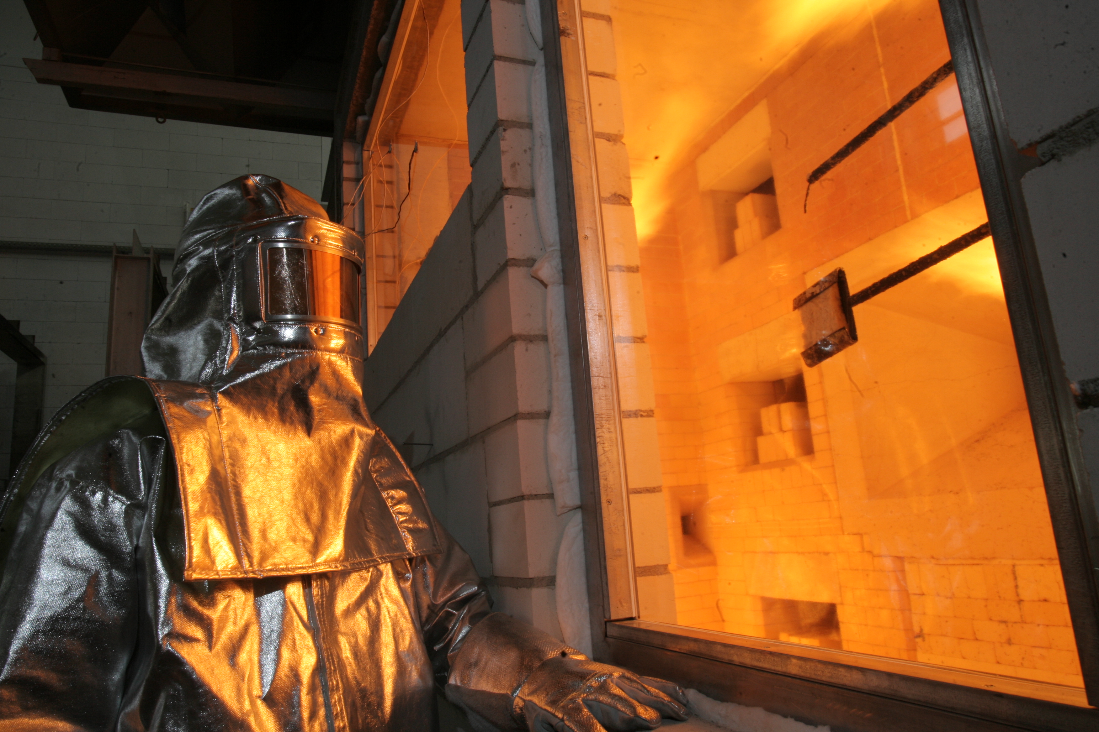 身穿耐热制服的工程师对玻璃进行防火测试 